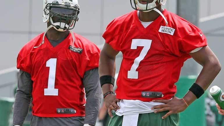 Jets QBs Michael Vick and Geno Smith watch during the...