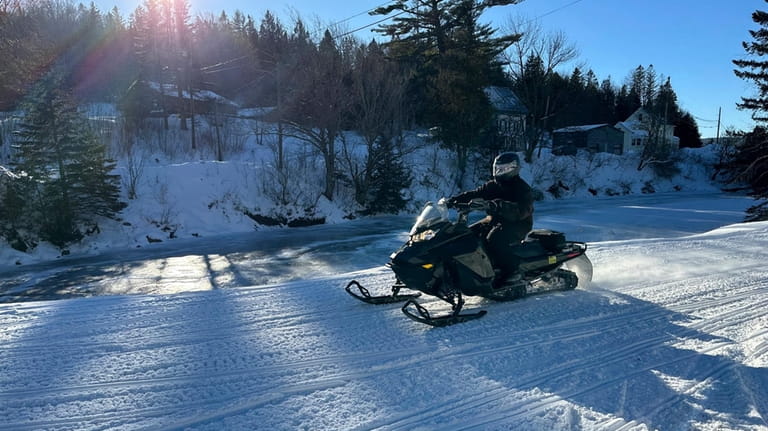 A snowmobiler rides on a trail in Danville, Vt., Sunday,...