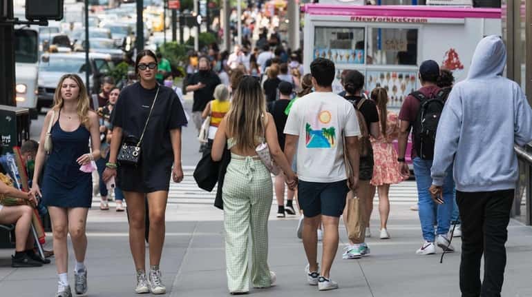 People walk down Fifth Avenue in Manhattan.