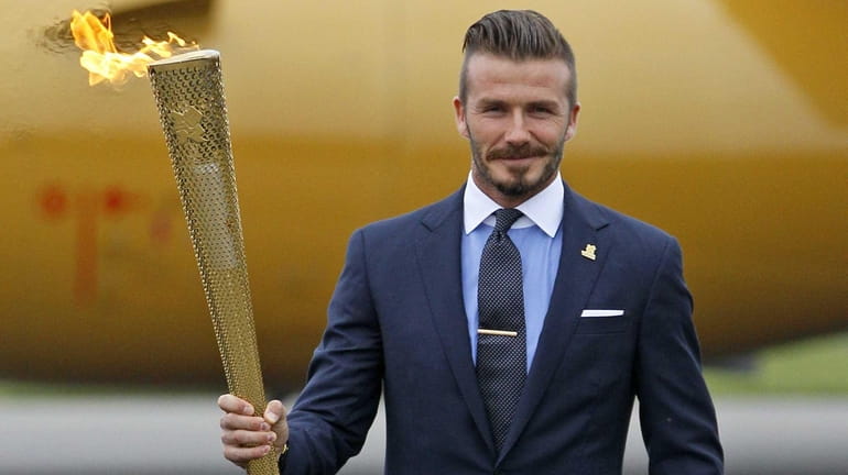 David Beckham holding the Olympic torch during the ceremony to...