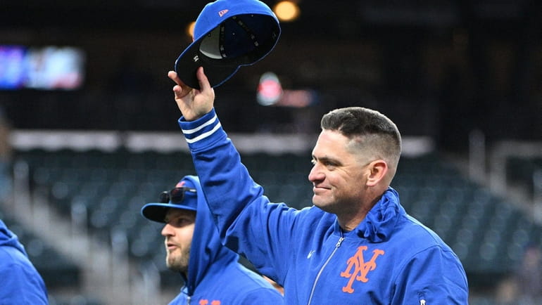 Mets manager Carlos Mendoza raises his cap after the 2-1...