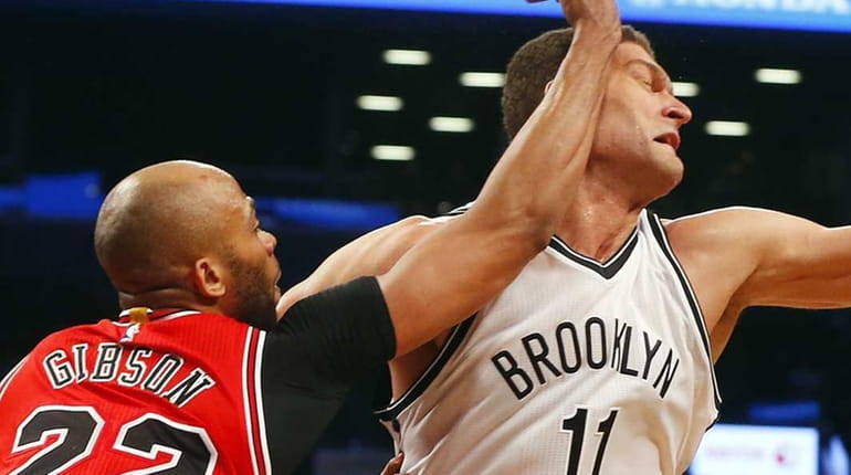 Brook Lopez of the Brooklyn Nets is fouled by Taj...