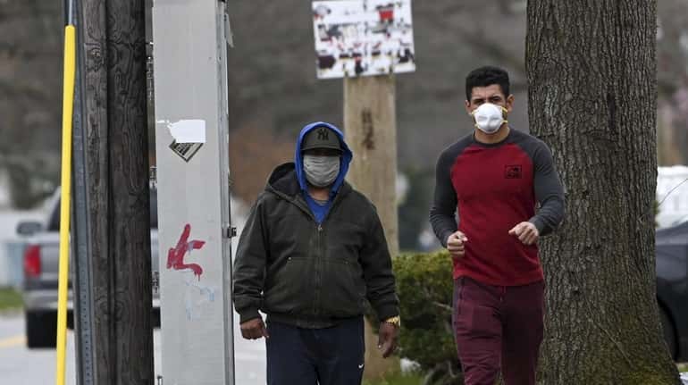 Two men wearing masks in Brentwood on April 5, 2020.