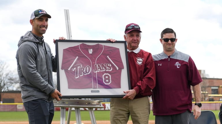 Former Garden City baseball coach Rich Smith (center) is presented with...