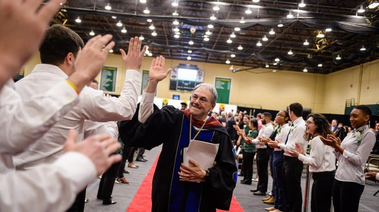 President John S. Nader gives high-fives to members of the...
