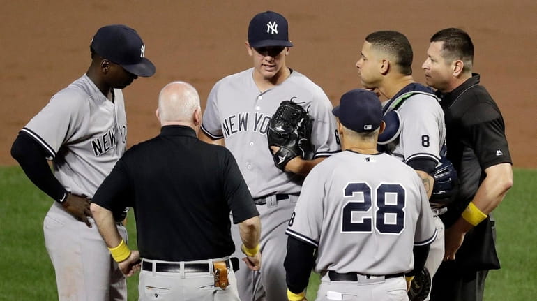 New York Yankees starting pitcher Chad Green, center, is relieved...