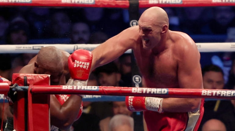 Tyson Fury, right, lands a punch during his WBC heavyweight...