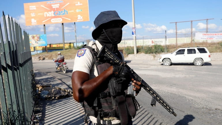 A National Police officer patrols an intersection in Port-au-Prince, Haiti,...