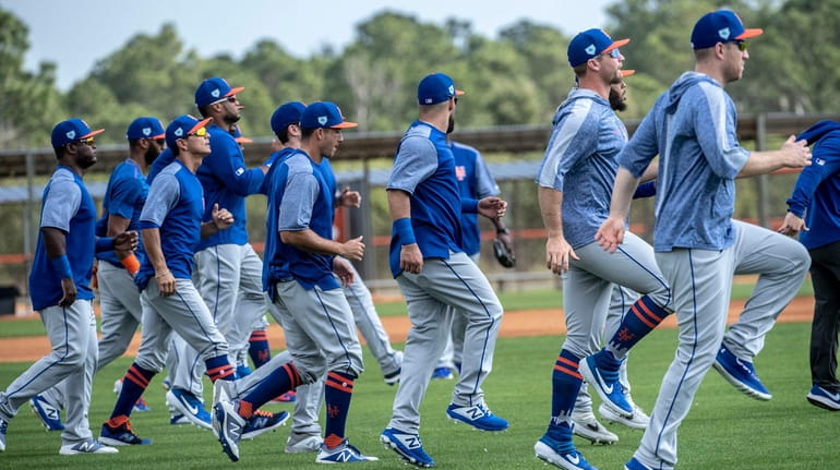 Mets players warm up during a spring training workout on...
