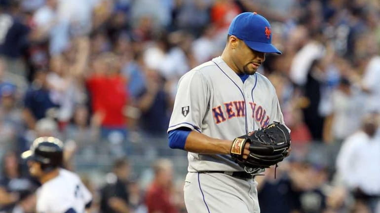 Johan Santana looks on after surrendering a third inning home...