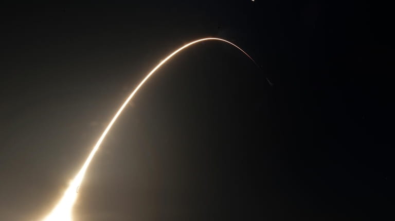 This time exposure photo shows a SpaceX Falcon 9 rocket,...