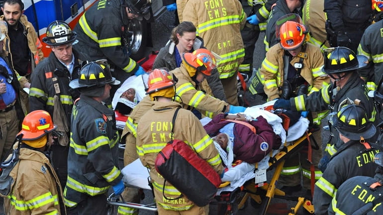 Emergency personnel offer treatment to a passenger of the Metro-North...