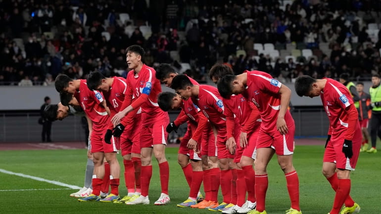 North Korea's players greet their supporters at the end of...