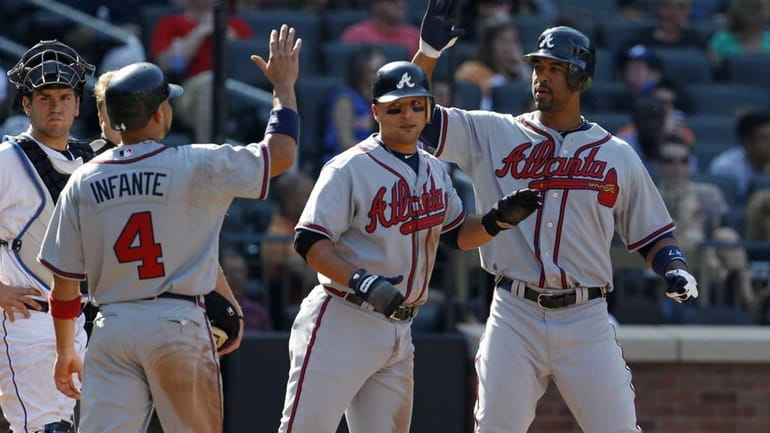 Atlanta Braves' Omar Infante (4) and Martin Prado, center, celebrate...