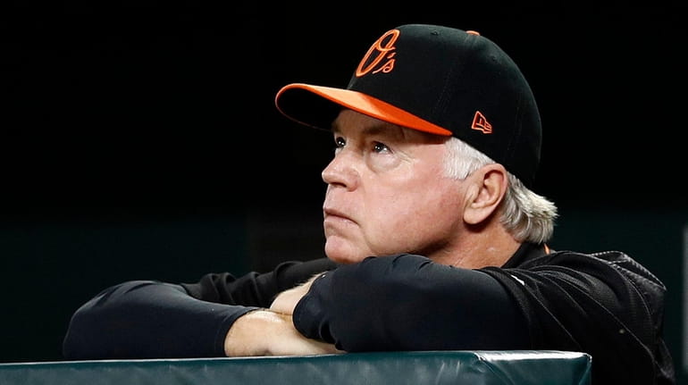 Orioles manager Buck Showalter watches from dugout railing in the...