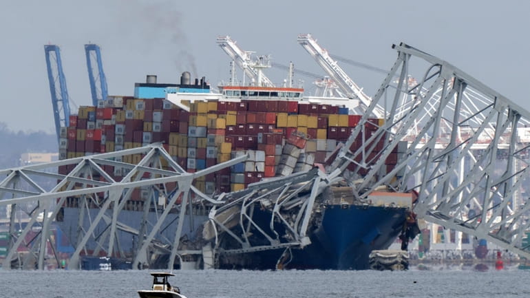 A container ship rests against the wreckage of the Francis...