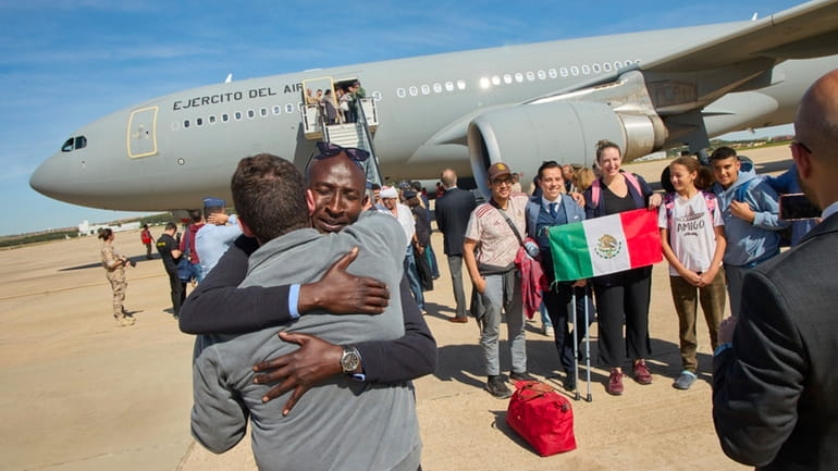 Passengers from Sudan disembark from a Spanish Air Force aircraft...