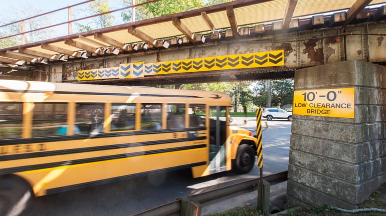 A school bus drives under the LIRR overpass at North...