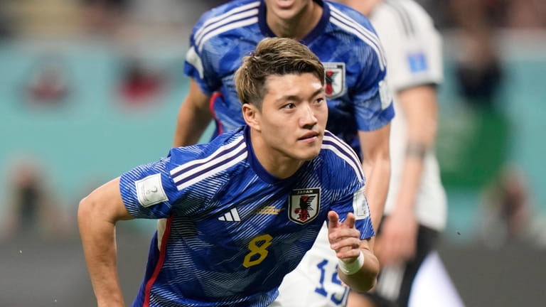 Japan's Ritsu Doan celebrates after scoring his side's opening goal...