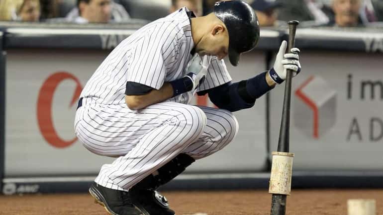 Derek Jeter #2 of the New York Yankees waits on...