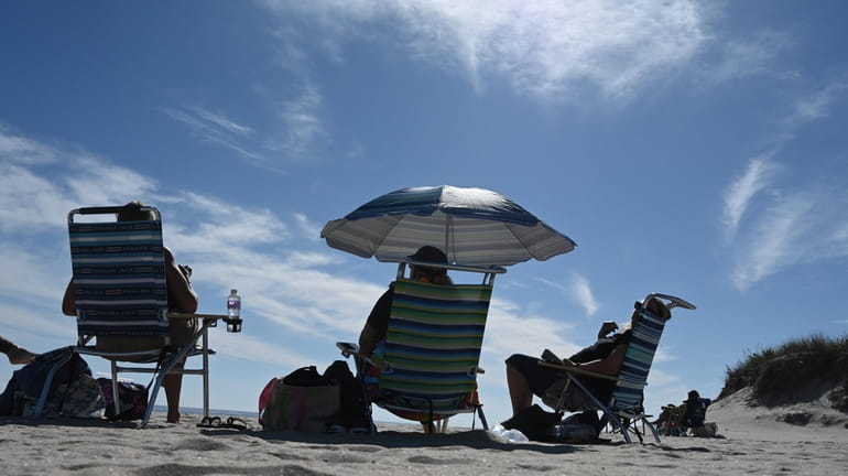 People enjoy blue skies on Coopers Beach in Southampton on...