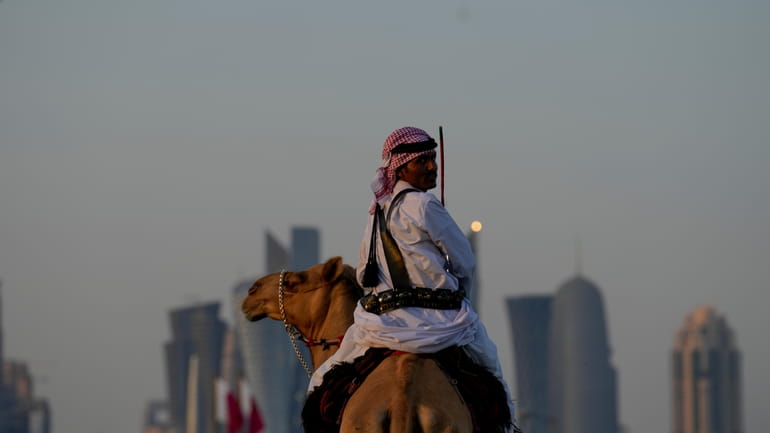 A guard rides his camels outside the Amiri Diwan in...