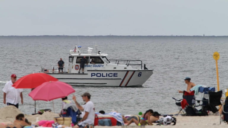 Officers aboard a Nassau County police boat scan the shoreline...