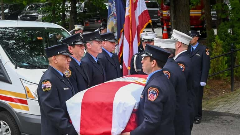 FDNY firefighters carry the casket of firefighter Jack McCauley at...