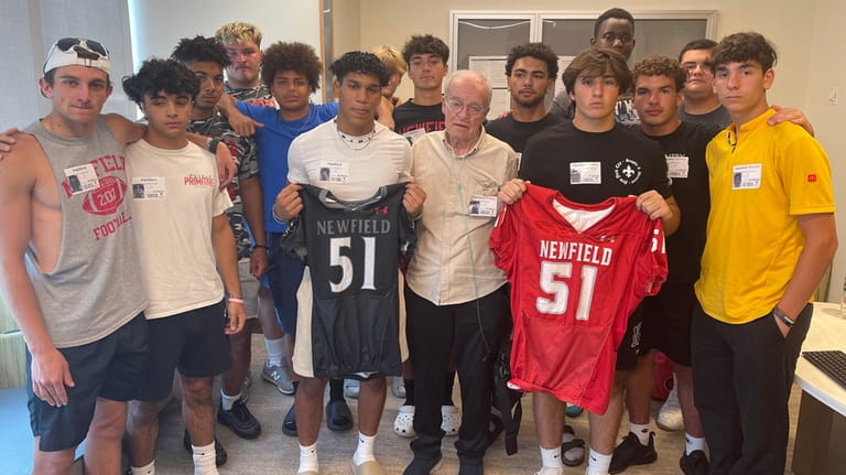 Robert Bush's Newfield High School football teammates and his father,...