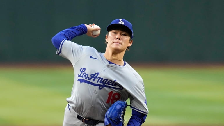 Los Angeles Dodgers starting pitcher Yoshinobu Yamamoto, of Japan, warms...
