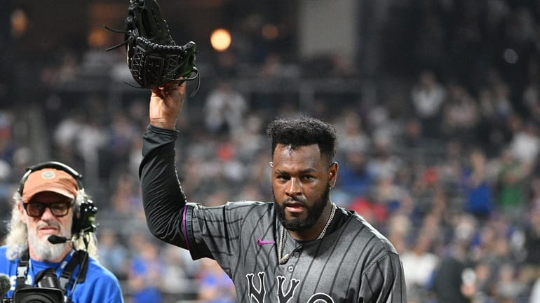 Mets starting pitcher Luis Severino raises his glove as he...